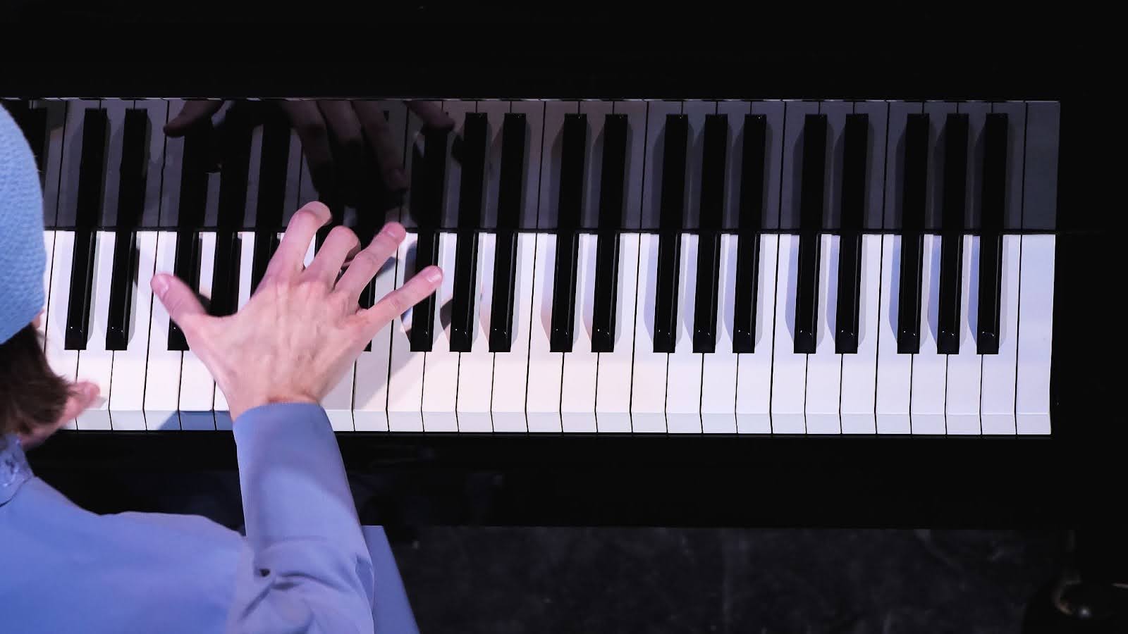 A close-up view of a man’s hand playing the piano